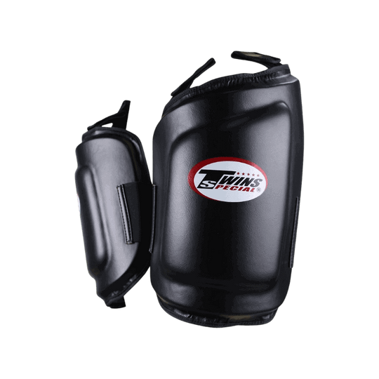 Zijkant van de Twins Special beenbeschermers, toont de dikte en beschermende lagen van de padding. Het logo is goed zichtbaar in het midden.