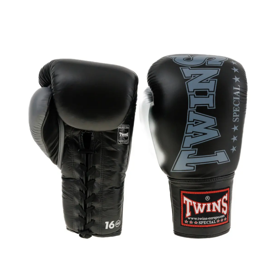 Een paar Twins bokshandschoenen in zwart met grijze details. De foto toont zowel de voorzijde met het Twins-logo als de achterzijde met veter­sluiting en 16 oz markering. Gemaakt voor intensieve bokssessies met maximale steun en duurzaamheid.
