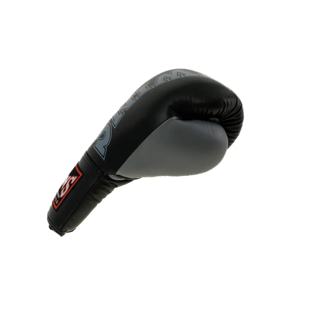 Een enkele Twins bokshandschoen in zwart en grijs, liggend op een witte achtergrond. De handschoen toont het Twins-logo op de polsband en heeft een strakke, professionele afwerking die ideaal is voor intensieve bokstrainingen.