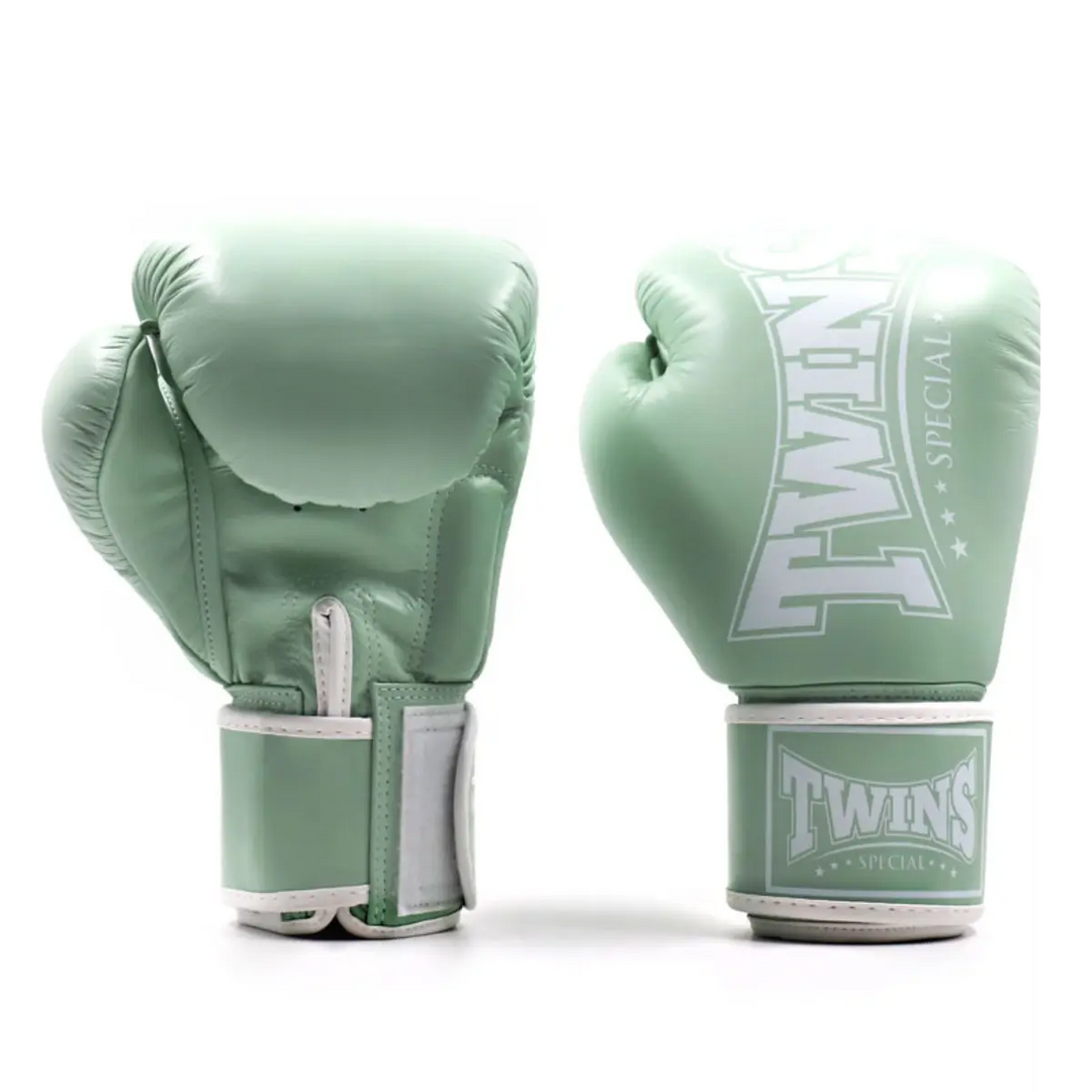 Een paar Twins bokshandschoenen in een stijlvolle mintgroene kleur, gemaakt van hoogwaardig leer met een stevige klittenbandsluiting. De handschoenen tonen het klassieke Twins-logo op de pols en zijn ontworpen voor intensieve bokstrainingen en sparring.