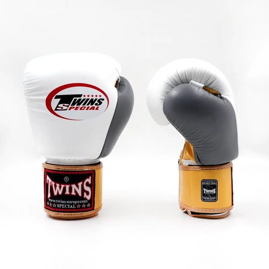Twins Special bokshandschoenen BGVL 4 Gold in wit met grijze palm en goudkleurige manchet op een witte achtergrond. Productfoto van twee bokshandschoenen rechtop naast elkaar, bedoeld voor de webshop.