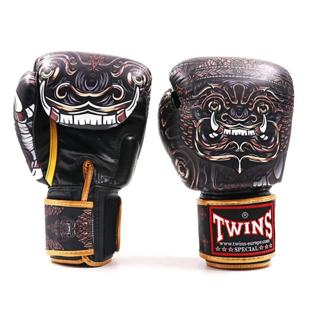 Twins Special bokshandschoenen BGVL FBGVL3-63 met zwart-goud ontwerp en gedetailleerde demon-print op een witte achtergrond. Productfoto van twee bokshandschoenen rechtop naast elkaar, bedoeld voor de webshop.