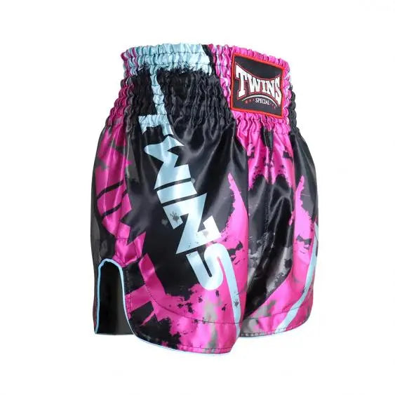 Twins Special Muay Thai short in zwart met roze en lichtblauwe accenten, voorzien van brede tailleband en opvallend TWINS-logo op de zijkant.