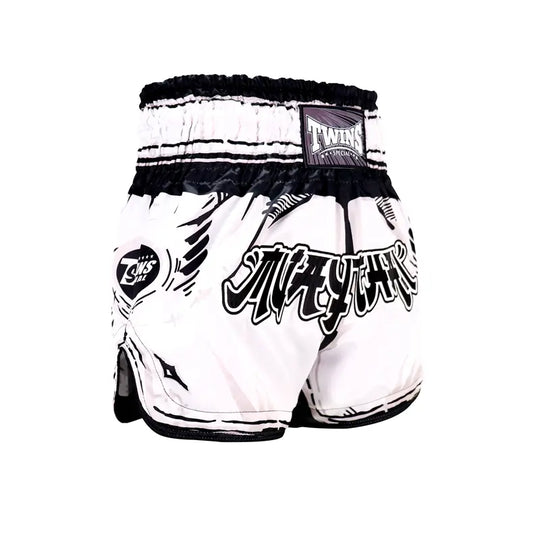 Twins Special Muay Thai short in wit met zwarte details, voorzien van brede tailleband en opvallende Muay Thai-opdruk.