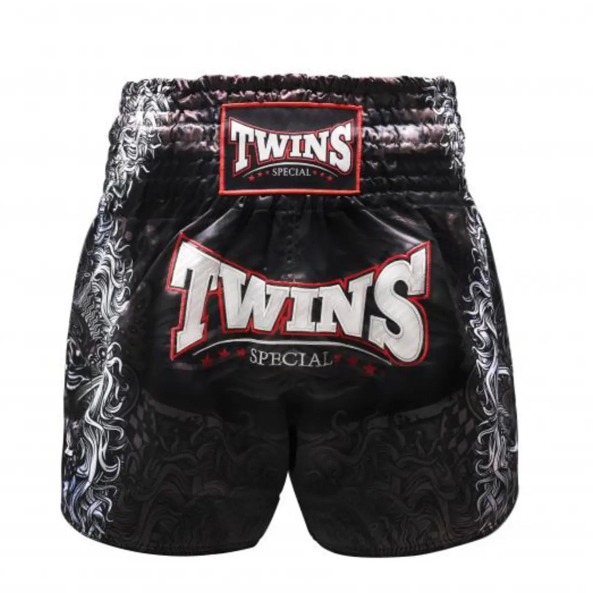 Achteraanzicht van het Twins Special kickboksbroekje in zwart, afgewerkt met een subtiele drakenprint aan de zijkanten en een extra groot TWINS-logo in rood-wit op de achterkant. De brede witte elastische tailleband met rood TWINS-label zorgt voor een stevige pasvorm. Gemaakt van hoogwaardig satijn polyester voor lichtheid en flexibiliteit tijdens elke training. Een statement short voor de kickbokser die kracht wil uitstralen.