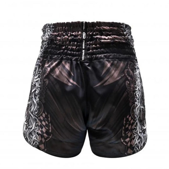 Achterzijde van het Twins Special kickboksbroekje met een gelaagd zwart design, gecombineerd met witte tribale zijpanelen. De elastische tailleband met TWINS-opdruk biedt een stevige pasvorm, ideaal voor explosieve combinaties tijdens het trainen. Het satijn polyester materiaal zorgt voor comfort en bewegingsvrijheid, terwijl de afwerking kracht en mystiek uitstraalt. Perfect voor kickboksers die op zoek zijn naar balans tussen stijl en functionaliteit.