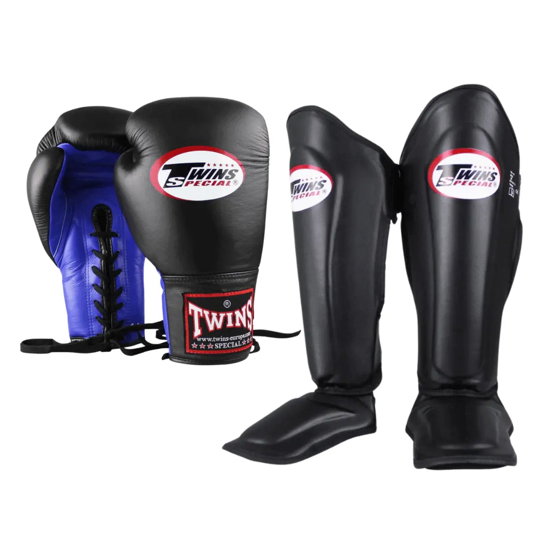 Set Twins Special kickboks set in zwart, bestaande uit zwart-blauwe veter-bokshandschoenen en zwarte scheenbeschermers met wit-rood Twins Special logo.