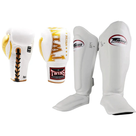 Twins Special set met witte bokshandschoenen en scheenbeschermers, afgewerkt met gouden accenten, ideaal voor kickboksers en thaiboksers.