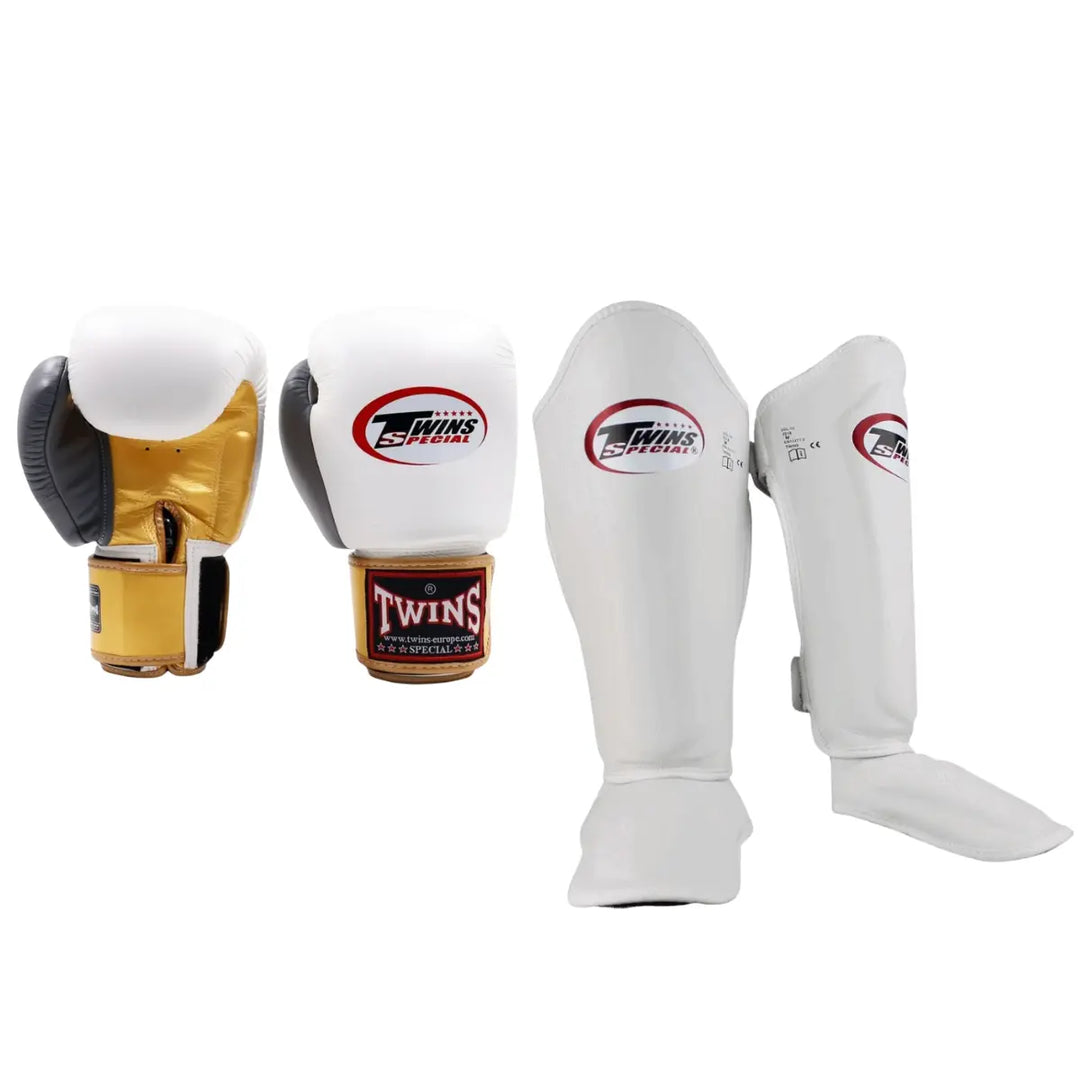 Twins Special bokshandschoenen en scheenbeschermers in wit met rood logo, ideaal voor kickboksers die stijl en bescherming willen combineren.