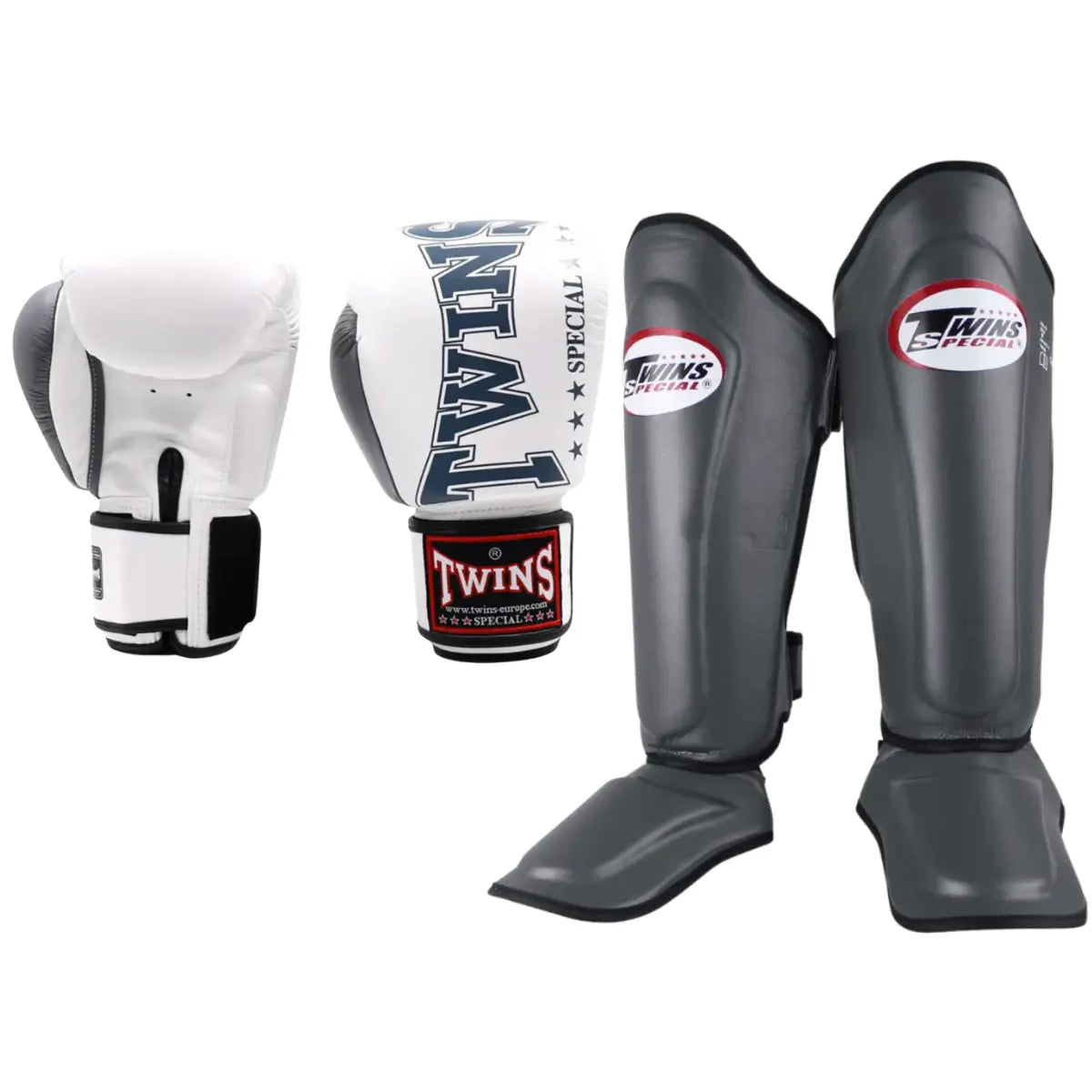 Set van Twins Special bokshandschoenen in wit met zwarte accenten en grijze scheenbeschermers met rood-wit logo, geschikt voor kickboksen en MMA.