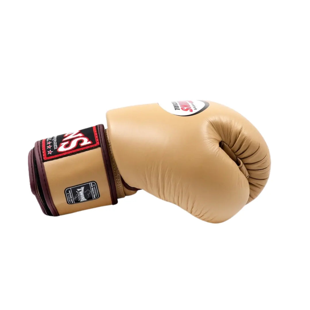 Twins Special Bokshandschoen Latte – Zijaanzicht van een premium leren bokshandschoen in latte-kleur met contrasterende bordeaux details. De stevige klittenbandsluiting en dikke padding bieden uitstekende polsondersteuning en bescherming tijdens bokstraining of sparring. Ontworpen voor langdurig comfort en professionele prestaties.