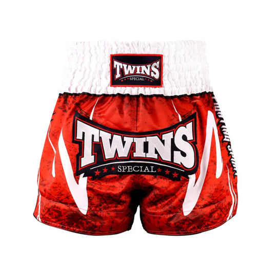 Vooraanzicht van het rood-zwarte Twins Special kickboksbroekje met wit logo en brede witte tailleband. De satijn polyester stof geeft een luxe glans en zorgt voor optimale bewegingsvrijheid tijdens trappen en knieën. Ideaal voor kickboksers die willen opvallen in stijl én comfort. Het traditionele Thaise design geeft de broek een krachtige uitstraling.