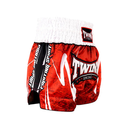Zijaanzicht van het opvallende Twins Special kickboksbroekje in rood met witte accenten en zwarte zijpanelen waarop ‘Fighting Spirit’ staat. De elastische tailleband biedt perfecte grip en comfort, terwijl de hoge uitsnede bewegingsvrijheid garandeert. Ideaal voor krachtige trappen, knieën en explosieve combinaties. Gemaakt van lichtgewicht satijn polyester voor topprestaties in de gym.