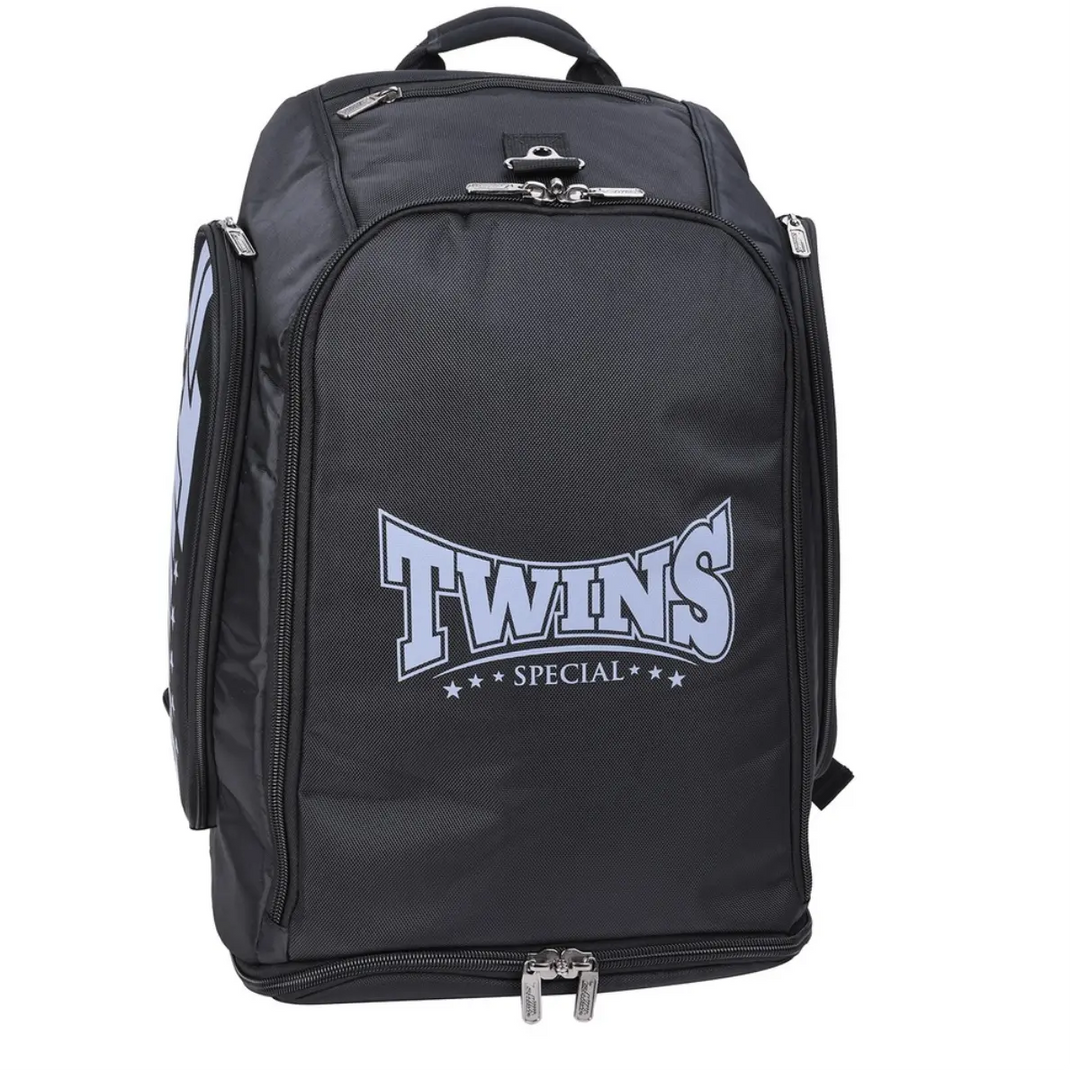 Vooraanzicht van de zwarte Twins Special rugzak met het iconische blauwe logo. De tas is voorzien van meerdere ritsvakken, inclusief een apart ondervak voor natte kleding of scheenbeschermers. Ideaal voor kickboksers die hun gear georganiseerd willen vervoeren.