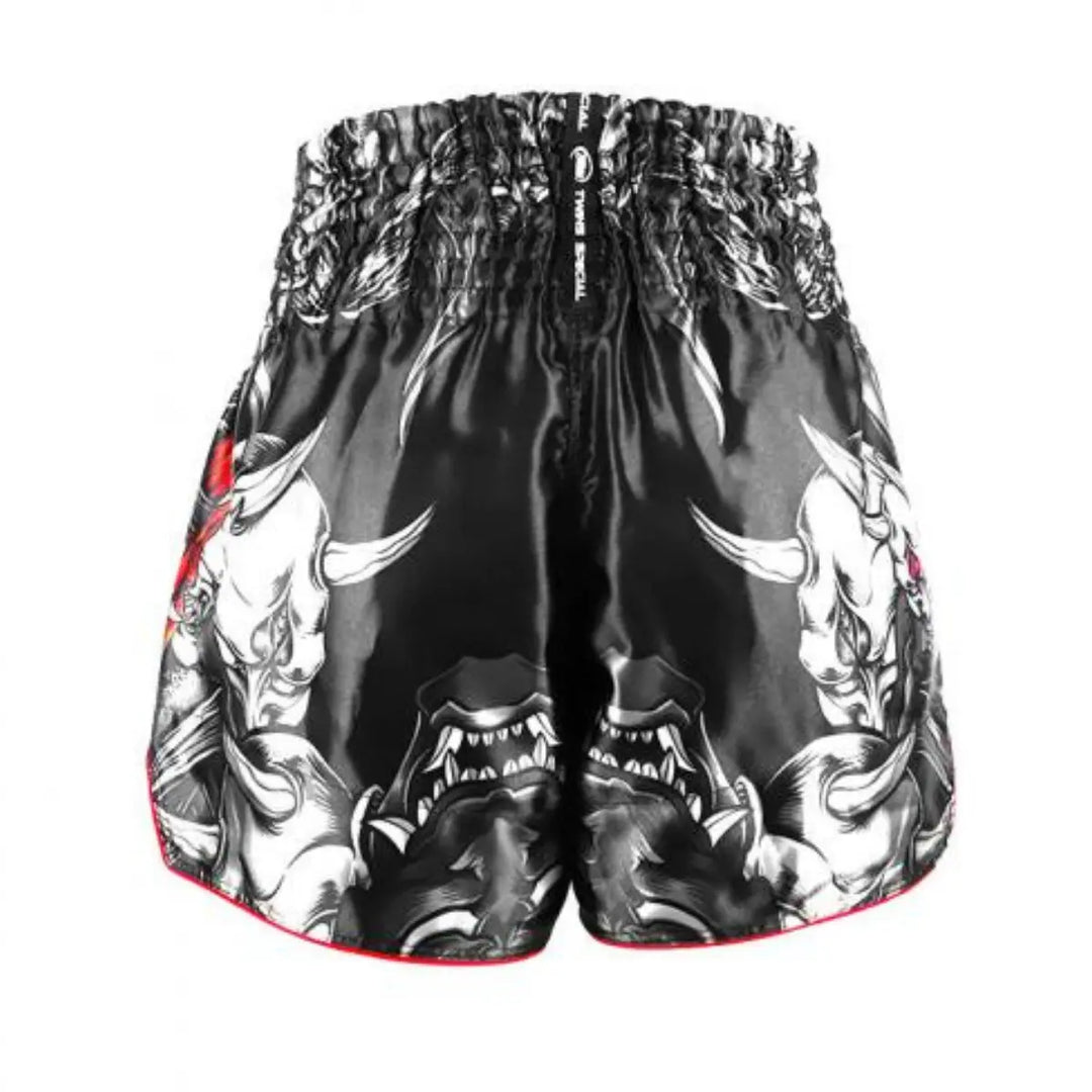 Achteraanzicht van een zwart kickboksbroekje van Twins Special met witte Oni-skullprints. De print toont scherpe tanden, horens en gespierde vormen. Het broekje heeft een brede elastische tailleband en is gemaakt van glanzend satijn polyester.