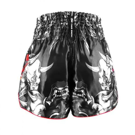 Achteraanzicht van een zwart kickboksbroekje van Twins Special met witte Oni-skullprints. De print toont scherpe tanden, horens en gespierde vormen. Het broekje heeft een brede elastische tailleband en is gemaakt van glanzend satijn polyester.