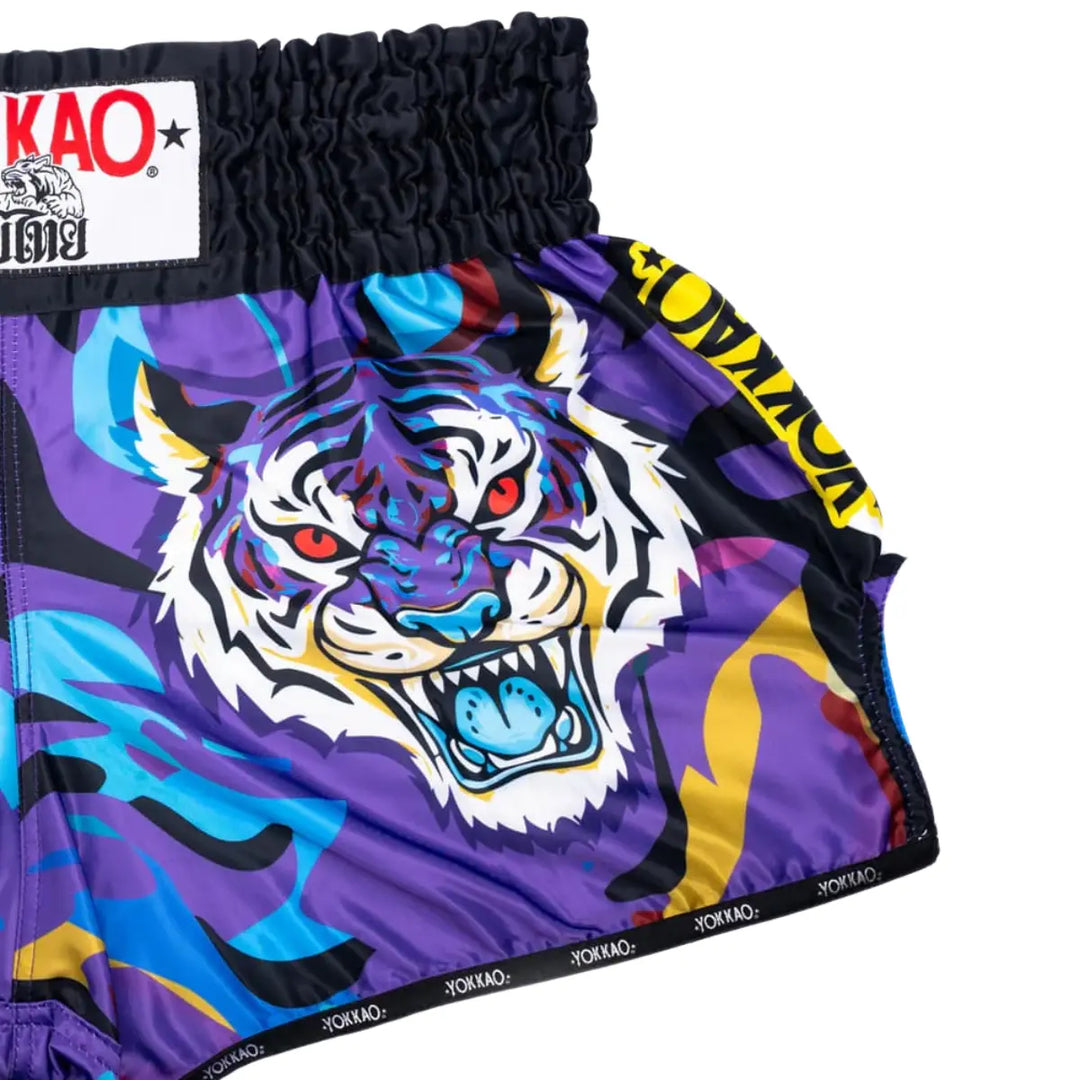Voorzijde van het YOKKAO Angry Tiger kickboks broekje met grote tijgerprint in paars en blauw. De felle kleuren en grafische lijnen geven het short een krachtige uitstraling. Ideaal voor explosieve bewegingen in de gym.