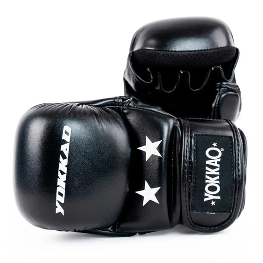 Yokkao MMA Handschoenen Zwart – close-up van zwarte open-finger handschoenen. Voorgevormde knokkelpadding, twee witte sterren op de polsflap en YOKKAO-logo duidelijk zichtbaar. Geperforeerde palm voor ventilatie en klittenbandsluiting voor een stevige, verstelbare pasvorm tijdens grappling en striking.