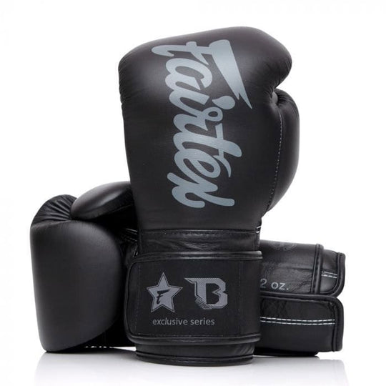 Een paar zwarte Fairtex bokshandschoenen met een grijs logo op een witte achtergrond.
