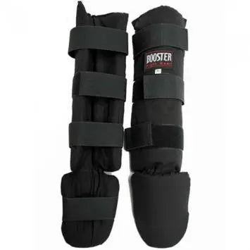 Een paar dikke, zwarte Booster Fight Gear 'Curved' scheenbeschermers voor vechtsporten, duidelijk tonend de klittenbandsluitingen en de bescherming voor de wreef, op een witte achtergrond.