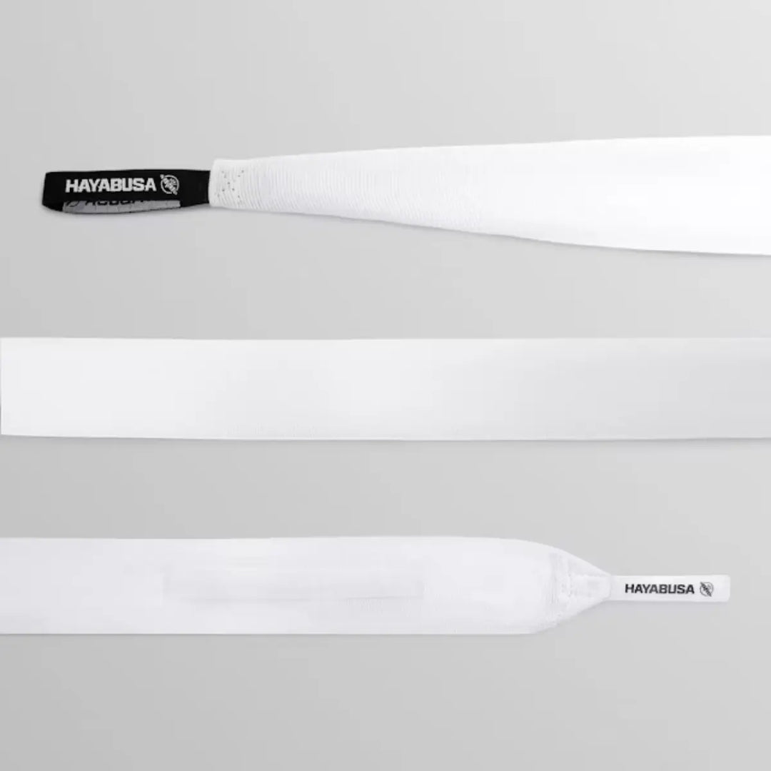 Productdetail van witte Hayabusa handwraps, met een opgerolde band, een plat stuk stof, en het logo op de lus voor de duim.