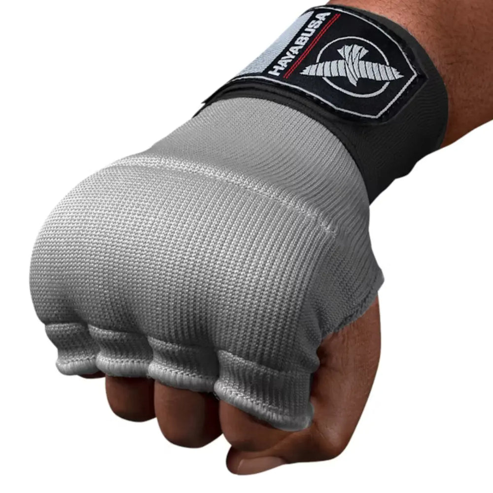 Close-up van een gebalde vuist met de grijze, vingerloze Hayabusa binnenhandschoen en de zwarte polsband met het logo