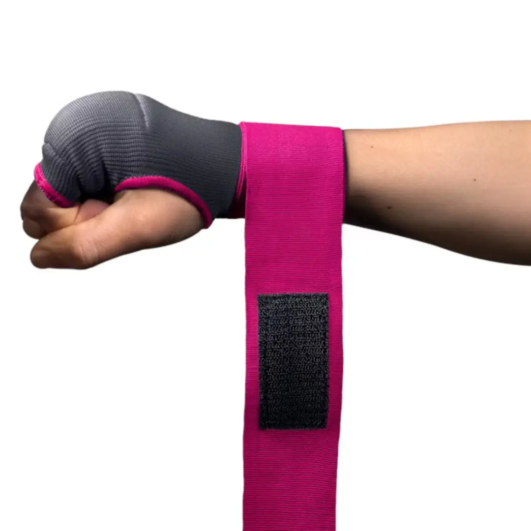 Close-up detail van een vuist ingepakt met de grijze Hayabusa quick wrap en de lange, felroze polsbandage met het zwarte klittenbandgedeelte.