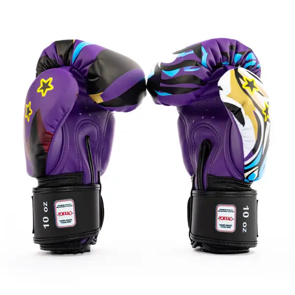 Twee Yokkao Angry Tiger bokshandschoenen rechtop gefotografeerd tegen een witte achtergrond met zichtbaar achteraanzicht. De paarse handschoenen tonen ventilatiegaatjes en zwarte klittenbandsluiting met 10 oz label. Het kleurrijke design met sterren en grafische accenten loopt door over de zijkanten.