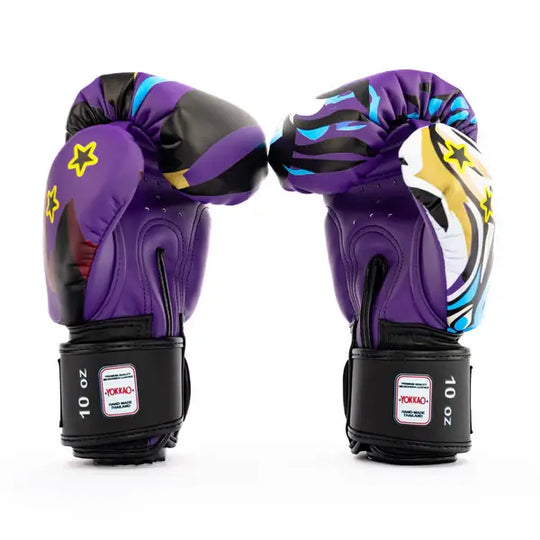 Twee Yokkao Angry Tiger bokshandschoenen rechtop gefotografeerd tegen een witte achtergrond met zichtbaar achteraanzicht. De paarse handschoenen tonen ventilatiegaatjes en zwarte klittenbandsluiting met 10 oz label. Het kleurrijke design met sterren en grafische accenten loopt door over de zijkanten.