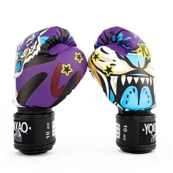 Twee Yokkao Angry Tiger bokshandschoenen rechtop tegen een witte achtergrond, waarbij zowel de zijkant als de voorkant zichtbaar is. De paarse handschoenen tonen gele sterdetails, een kleurrijke tijgerprint en blauwe accenten. Op de zwarte klittenbandsluiting is het 10 oz label duidelijk zichtbaar.