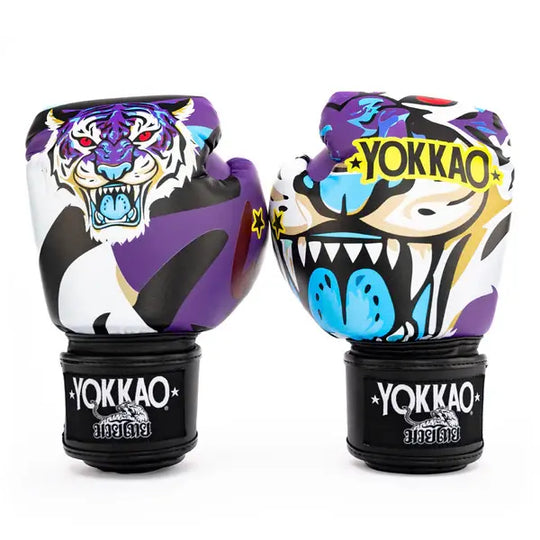 Twee Yokkao Angry Tiger bokshandschoenen rechtop tegen een witte achtergrond met duidelijk zicht op de voorzijde. De paarse handschoenen tonen een gedetailleerde tijgerillustratie met rode ogen en blauwe accenten, samen met het gele YOKKAO-logo. De zwarte klittenbandsluitingen dragen het Yokkao-logo en het 10 oz label.