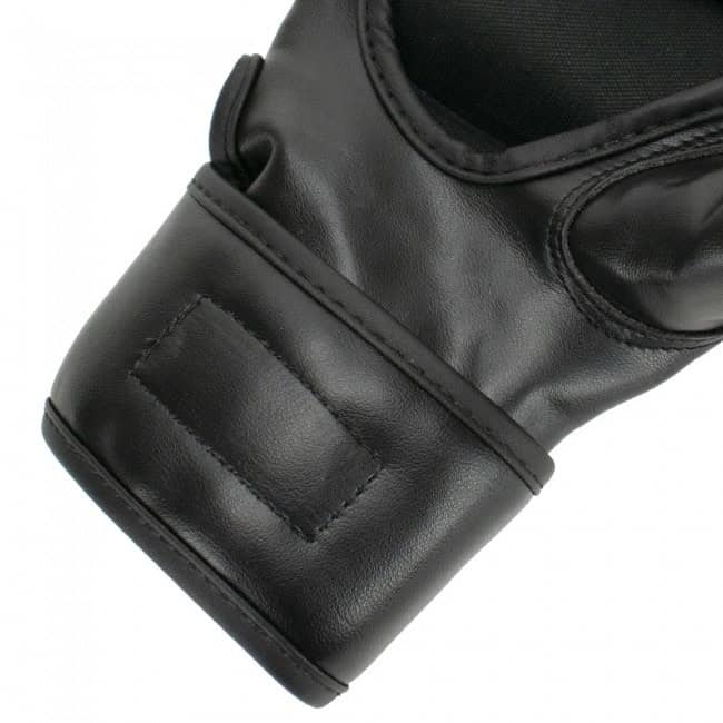 Close-up van de polsband van de zwarte Super Pro MMA handschoenen Brawler. De polsband is gemaakt van duurzaam kunstleer en heeft een stevige sluiting met klittenband voor optimale ondersteuning en een veilige pasvorm. De handschoenen zijn ontworpen om de pols te stabiliseren tijdens trainingen en wedstrijden, waardoor het risico op blessures wordt verminderd. Het soepele en stevige materiaal biedt comfort en duurzaamheid voor intensief gebruik.
