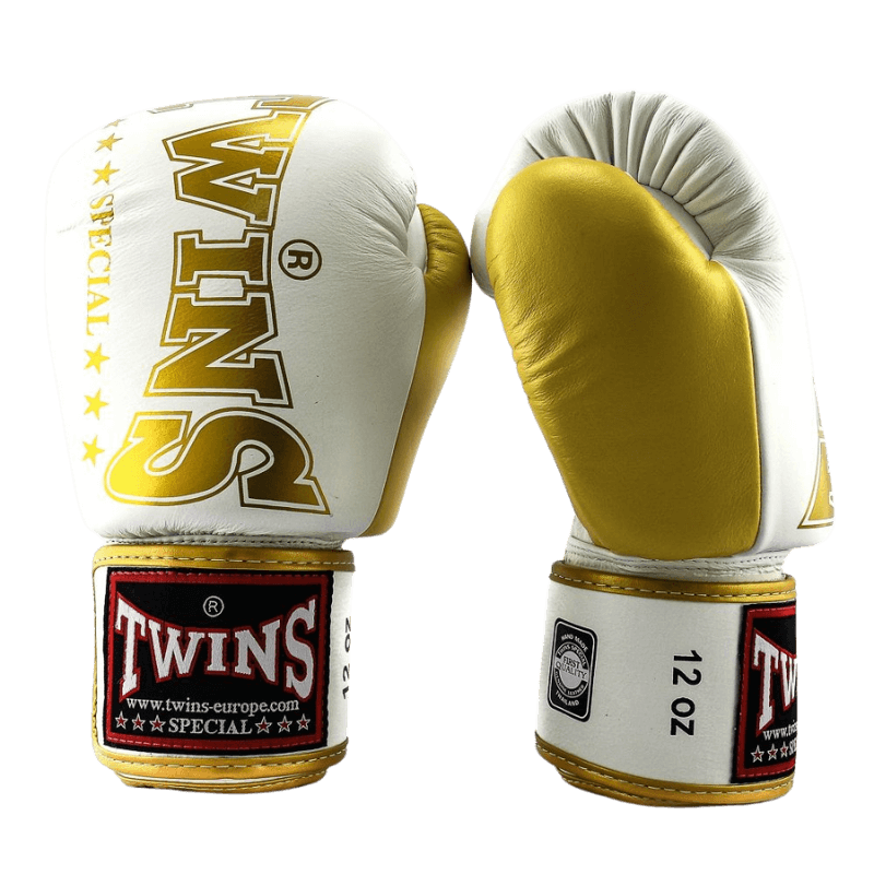 Paar witte Twins bokshandschoenen BGVL 8 met gouden TWINS logo op de rug en geel-gouden palm en polsband.