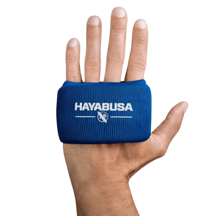 Een hand met een uitgestrekte palm waarbij een Hayabusa Boxing Knuckle Guard om de knokkels zit, met het logo en adelaarsembleem naar boven gericht.