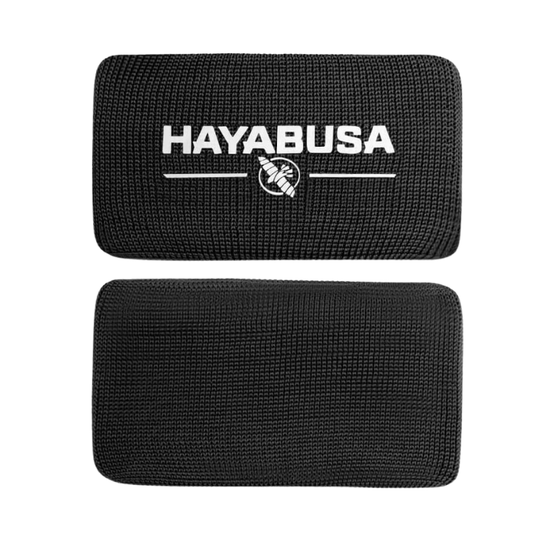 Een enkele zwarte Hayabusa Boxing Knuckle Guard met een zichtbaar wit Hayabusa-logo en adelaarsembleem, gepresenteerd tegen een donkere achtergrond.