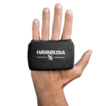 Een hand met de palm naar de camera gericht waarbij een zwarte Hayabusa Boxing Knuckle Guard wordt gedragen, met het witte Hayabusa-logo en adelaarsembleem bovenop de hand.