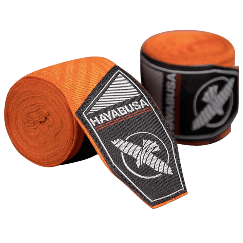 Een paar Hayabusa Perfect Stretch Bandages in de kleur oranje met een ingewikkeld doolhofpatroon, opgerold naast hun zwarte verpakking met het Hayabusa valk-logo in wit.