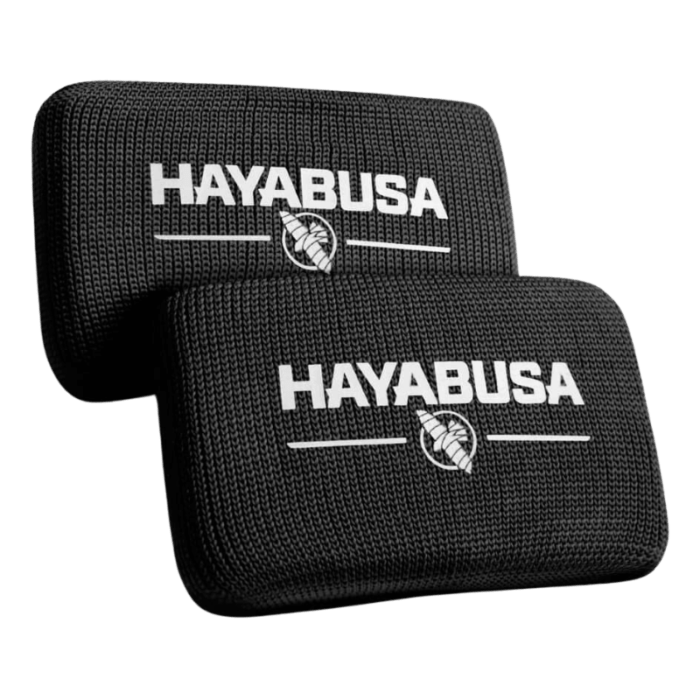 Twee zwarte Hayabusa Boxing Knuckle Guards met het Hayabusa-logo en het adelaarsembleem in wit, gestapeld op een donkere achtergrond.