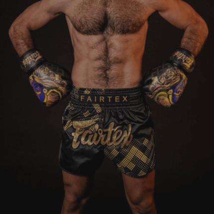 Een getrainde mannelijke vechtsporter van achteren gezien, met Fairtex bokshandschoenen en bijpassende shorts, poseert met gebalde vuisten en opgeheven armen om zijn gespierde rug en schouders te tonen.