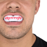Man toont hoe een SafeJawz mondbeschermer met roze hartontwerp in de mond zit.