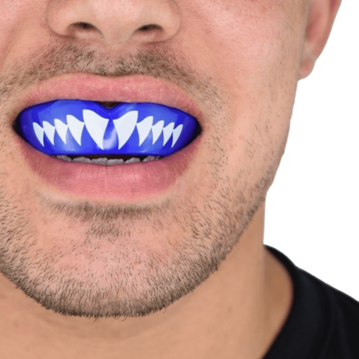 Close-up van iemand die een blauwe mondbeschermer draagt met een witte haai-tanden design.