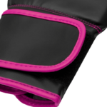 Detail van de polssluiting van een zwarte bokshandschoen met roze randen en stiksels.
