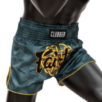Een mannequin draagt donkerblauwe Muay Thai shorts met een gouden Fairtex logo en het woord 'CLUBBER' op de tailleband, versierd met hetzelfde grijze weefselpatroon en gele bies.