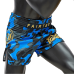 De Muay Thai shorts gedragen door een mannequin, tonen de blauwe camouflageprint, het 15-jarige jubileumlogo van Fairtex op de tailleband en het gouden Fairtex logo op de zijde.