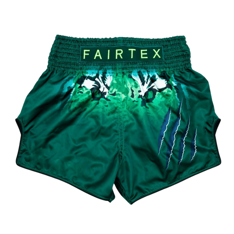 Fairtex groene Muay Thai shorts met camouflage en bliksemontwerp en witte Fairtex belettering.