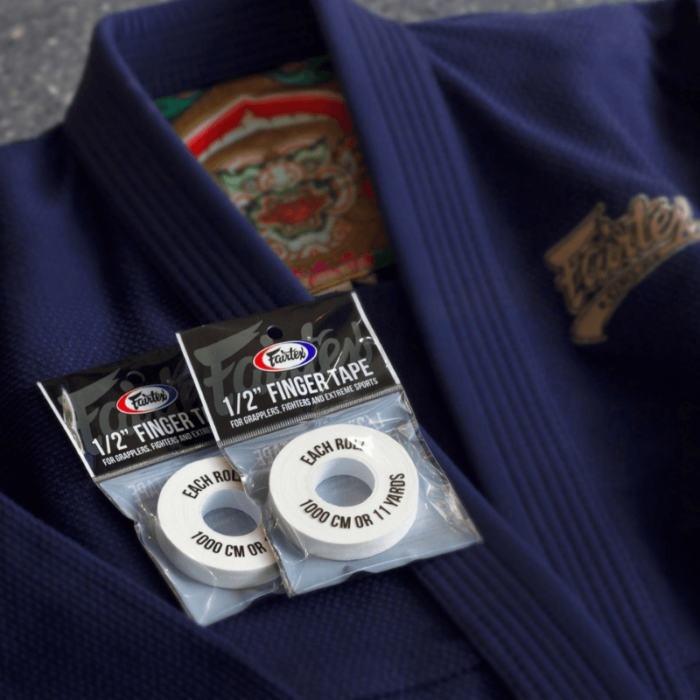 Twee verpakkingen van Fairtex vinger tape op een blauwe judogi.